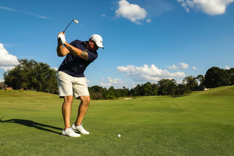 Ein Mann holt zum Golfschlag aus.